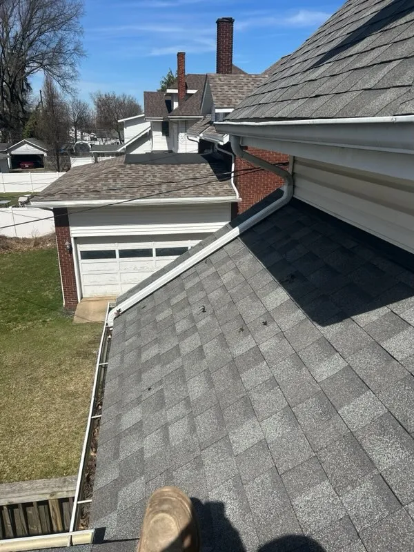 New architectural shingles across a garage roof and valley, meeting the siding