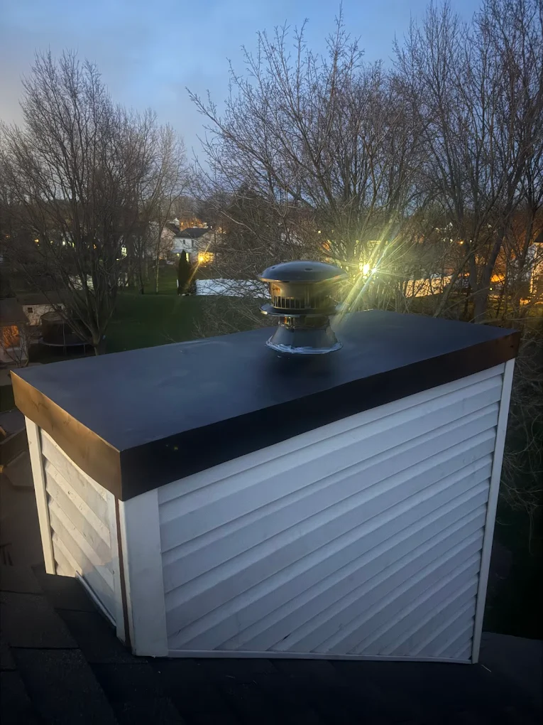 Dark roof edge and cap detail above white lap siding